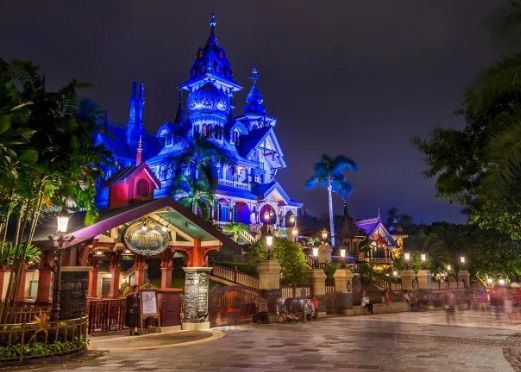 image of Disney parks Mystic Mansion shown at night light up by blue lights